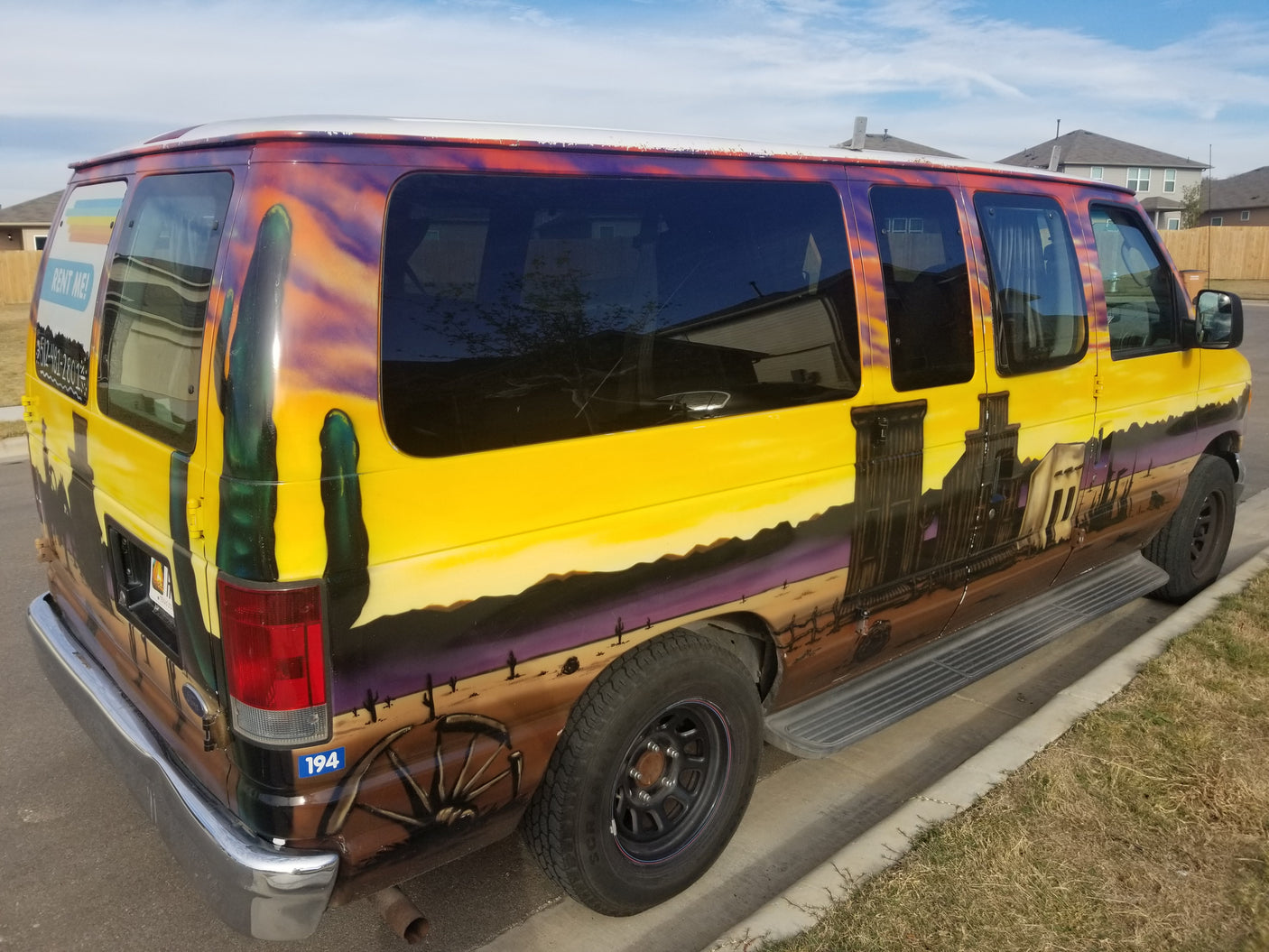 A vibrant, custom-painted van, featuring a desert and old west mural, available as an RV rental.