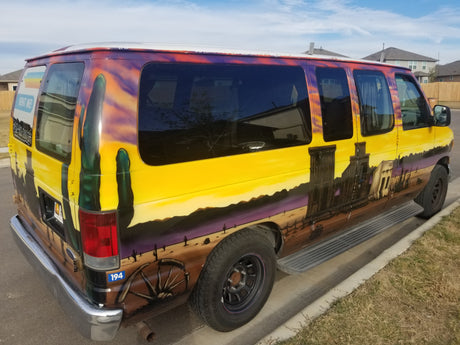 A vibrant, custom-painted van, featuring a desert and old west mural, available as an RV rental.