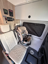 rv rental: Beige child car seat in a spacious RV interior with controls for Truma, Winnebago, and solar power.