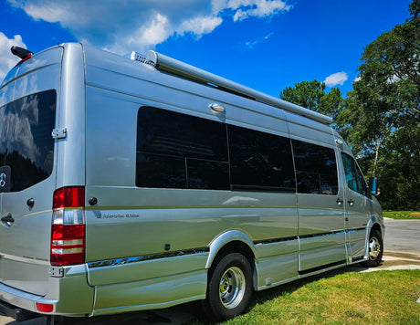 Silver Roadtrek CS Adventurous XL RV rental parked under a blue sky. Perfect camper van for your next adventure or road trip.