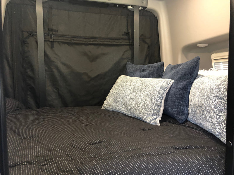 Comfortable RV rental bed with patterned comforter & throw pillows in a cozy interior, ideal for relaxation. — photo 7