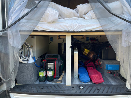 Explore this RV rental's clever under-bed storage: water tank, propane heater, and battery charger for camping comfort.