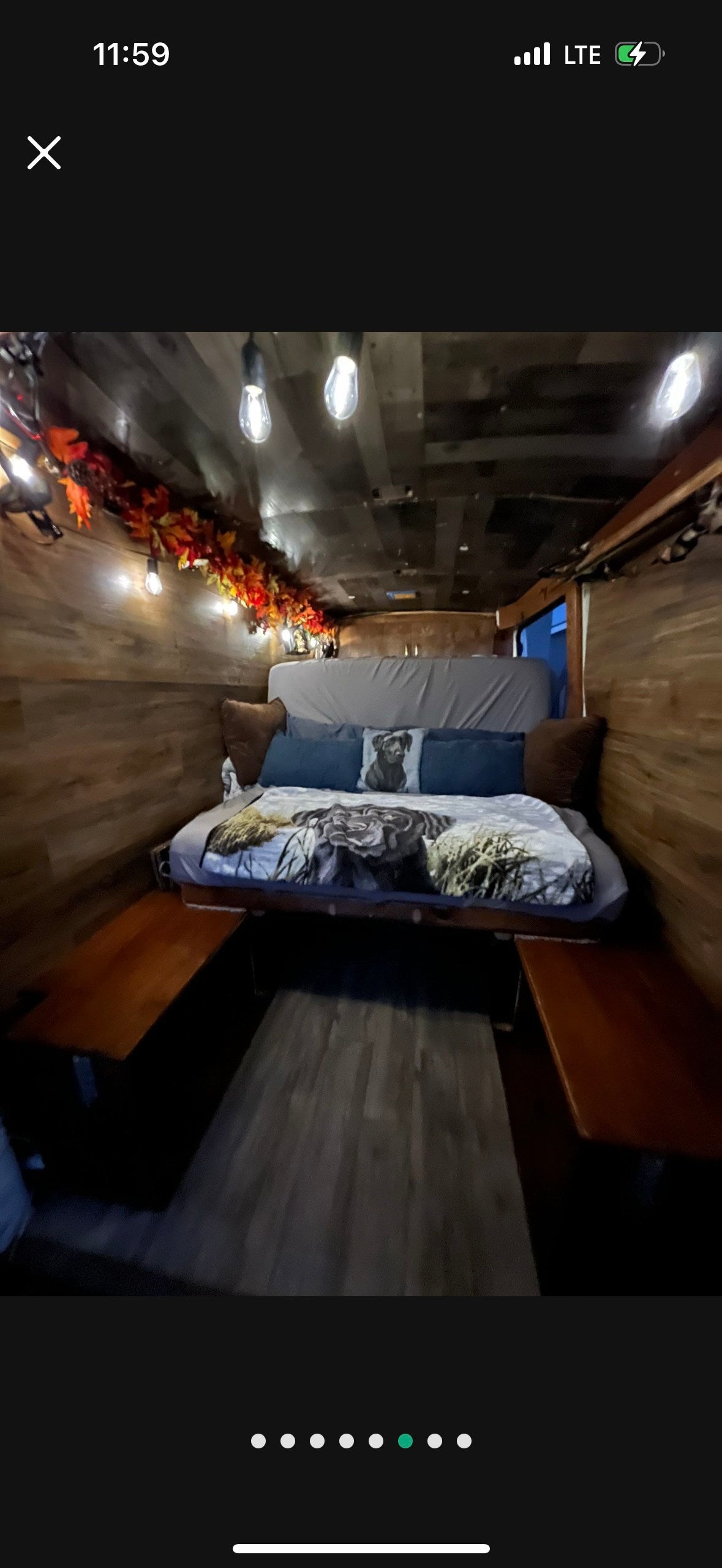 Cozy rv rental interior: wood-paneled bedroom features dog-themed bedding, string lights, and autumn leaf decor. — photo 6