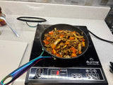 Sautéing ground meat, onions, peppers, and mushrooms on an induction cooktop, ideal for an RV rental kitchen.