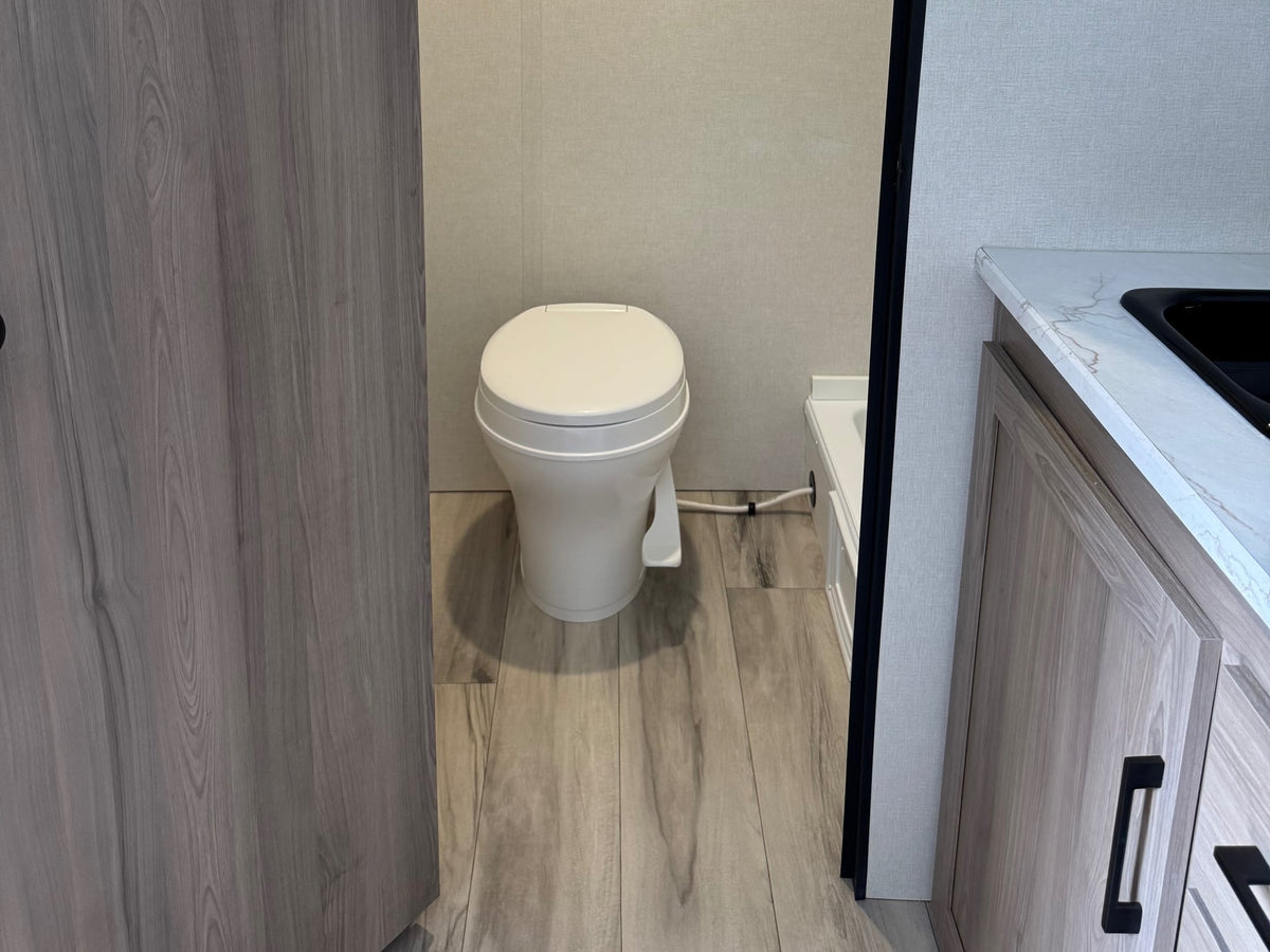  and bed area. This solar-ready travel trailer 13B is seen from the doorway.|RV rental interior shows a compact kitchen with a fridge — photo 6