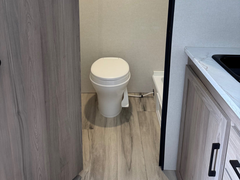  and bed area. This solar-ready travel trailer 13B is seen from the doorway.|RV rental interior shows a compact kitchen with a fridge — photo 6