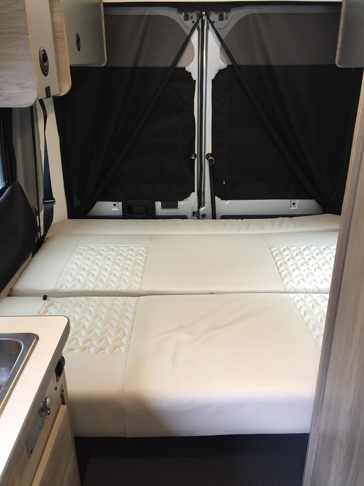  and wooden storage.|RV rental interior showing a compact shower with curtain — photo 12