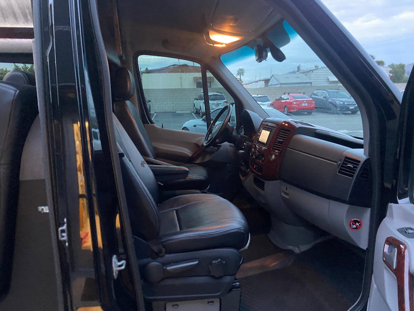 An RV rental's interior: view from the passenger side showing the spacious cockpit and front seats.