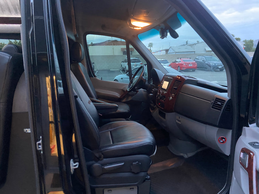 An RV rental's interior: view from the passenger side showing the spacious cockpit and front seats.