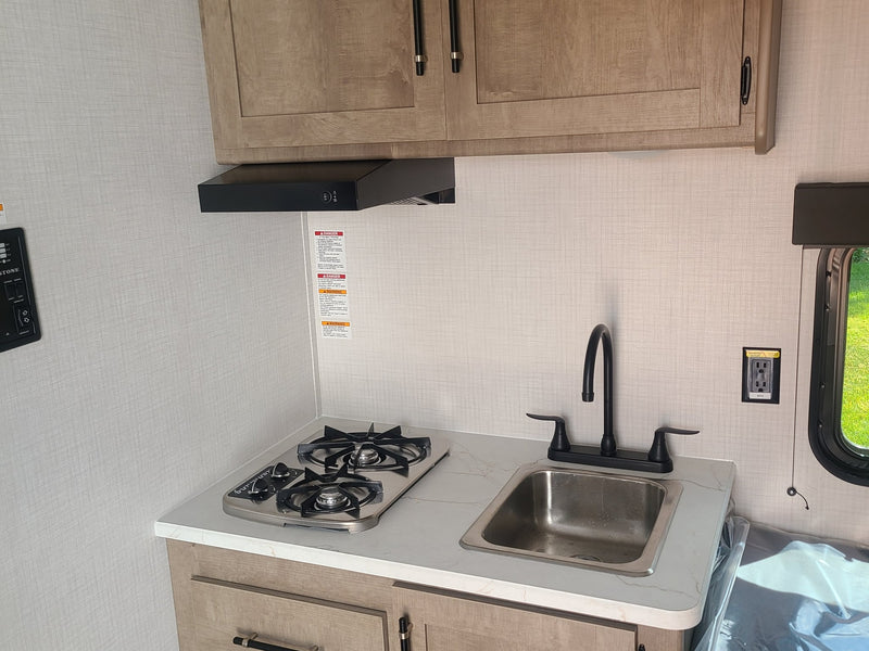  and rolled-up awning.|RV rental interior featuring a stacked High Pointe microwave and Furrion refrigerator — photo 5