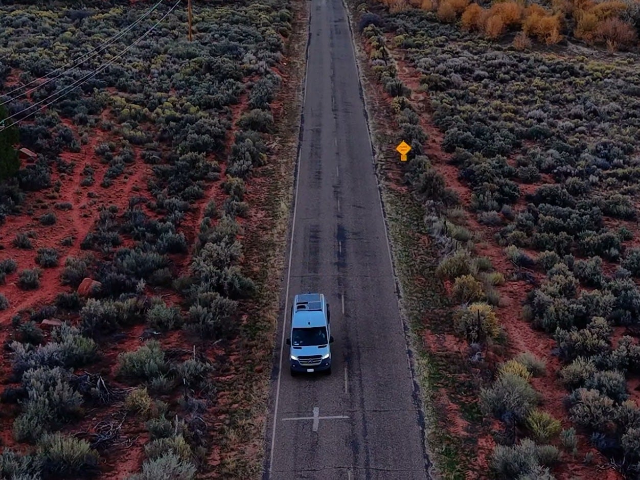 surrounded by red earth & scrub. Scenic drive ahead.|Light gray adventure van — photo 2