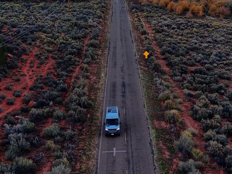  surrounded by red earth & scrub. Scenic drive ahead.|Light gray adventure van — photo 2