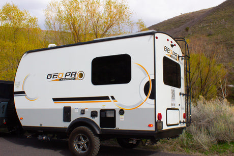 This white Geo Pro travel trailer, clearly marked "RENT ME" on the back, is available for RV rental.