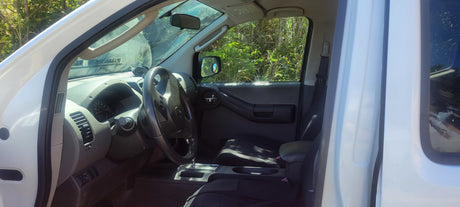 View into the driver's side of a white Nissan SUV, showcasing its clean interior. Perfect as a support vehicle for your RV rental.