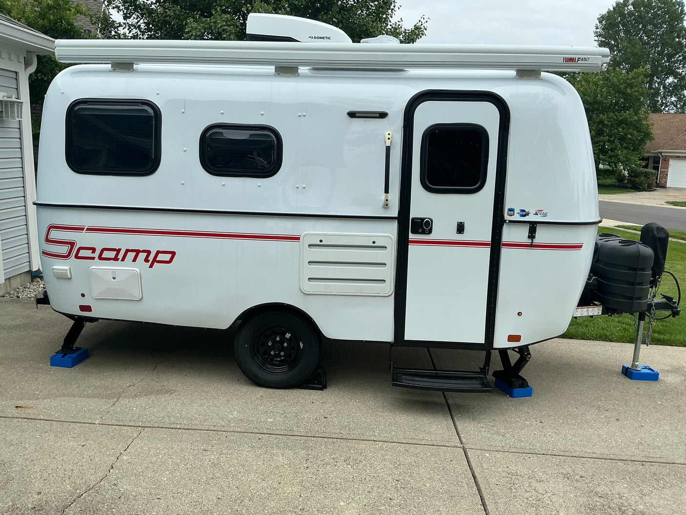  outfitted with electric bikes and camping gear for an outdoor escape.|A compact white RV rental with a Fiamma awning on top