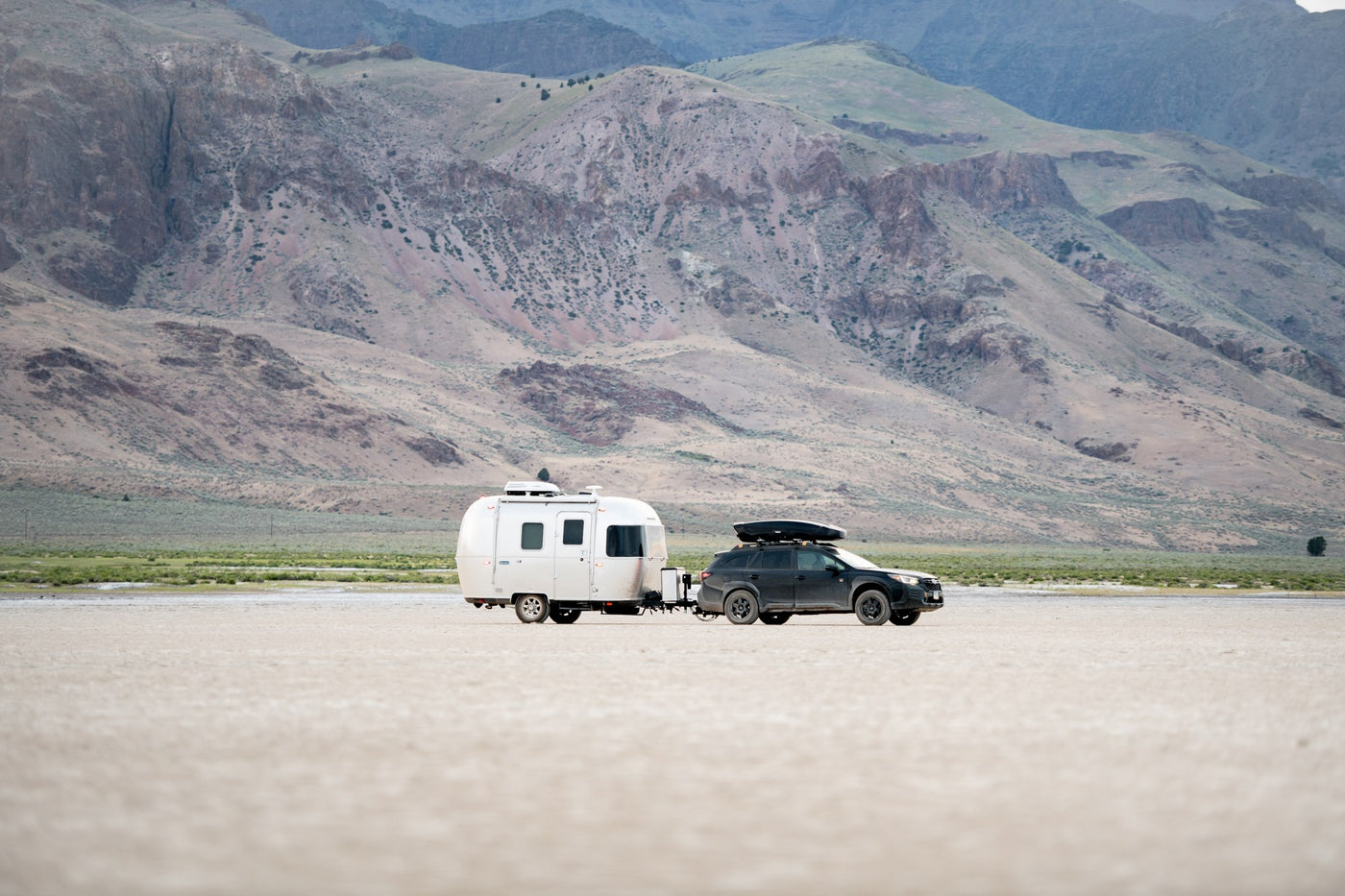  plus a small kitchen.|A sleek silver Airstream rv rental awaits in a serene forest. Its door is open — photo 5