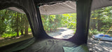 RV rental rooftop tent interior: a tranquil view of a tree-lined road, with cars, perfect for outdoor camping adventures.