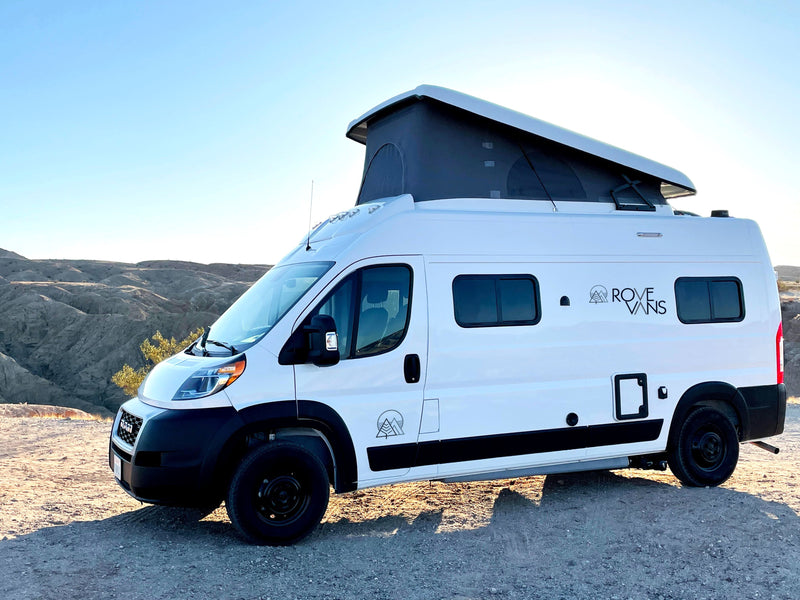White pop-top Rove Vans camper van for rv rental, parked on a gravel path in a desert landscape. — photo 15