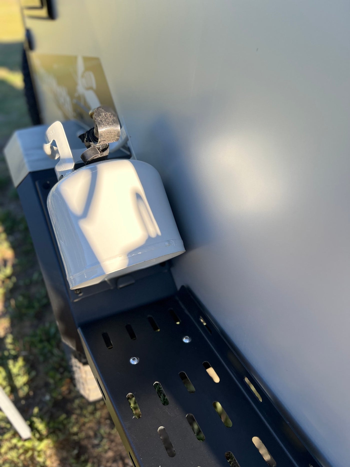 A white propane tank is securely mounted on the side of an RV rental, essential camping gear for travel trailers. — photo 19