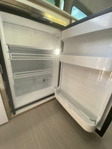 An open, clean RV rental refrigerator with shelves and crisper, ready for your travel provisions.