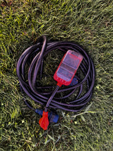 Essential for **rv rental** trips: A 30A RV power cord coiled on grass with a MarsFlex surge protector for safe hookups.