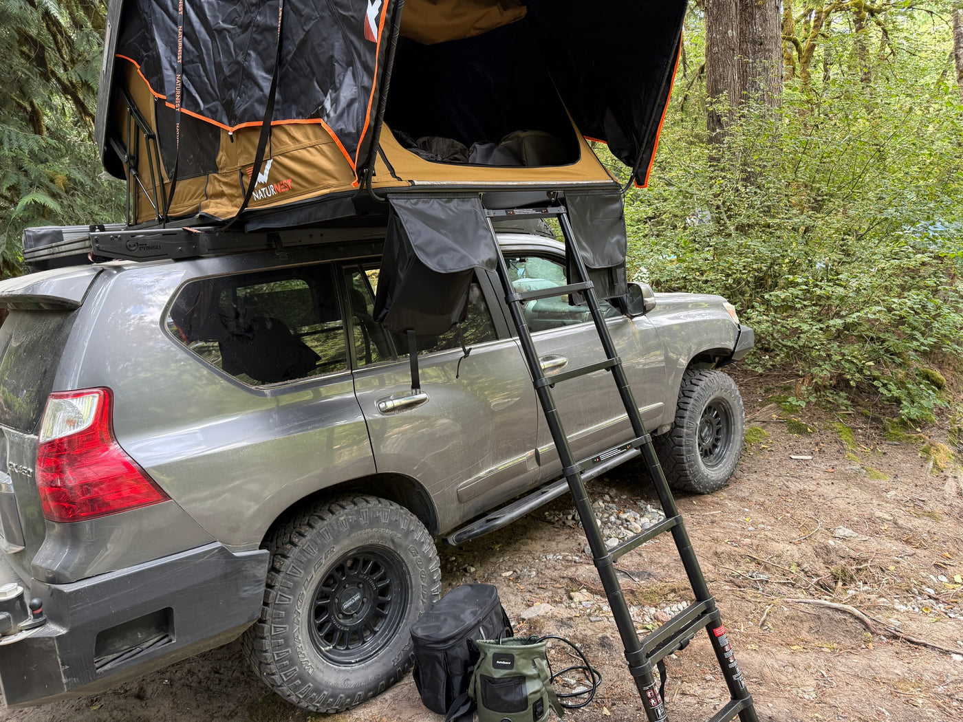  a perfect camping setup or RV rental alternative.|Lexus GX overlanding vehicle with NaturNest rooftop tent & ladder in a forest — photo 9