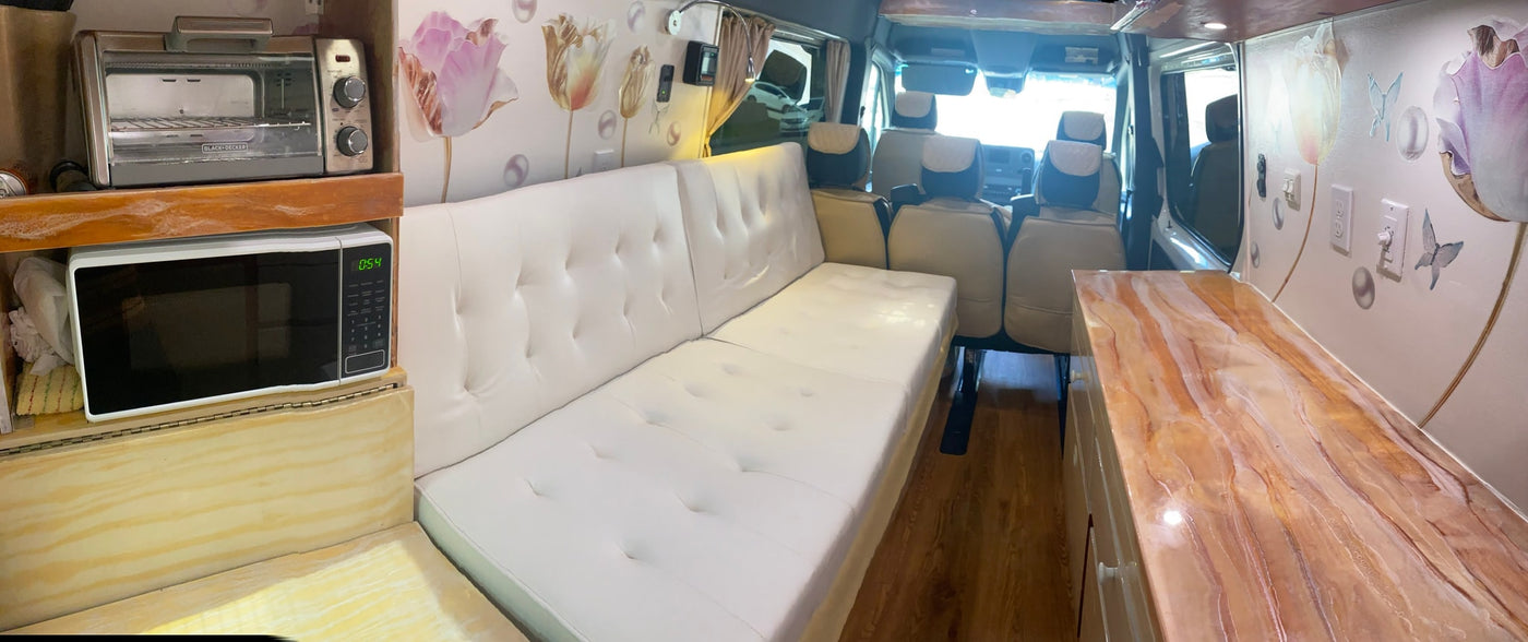 RV rental: comfy white sofa/bed, microwave, toaster oven, and decorative floral & butterfly wall. — photo 5