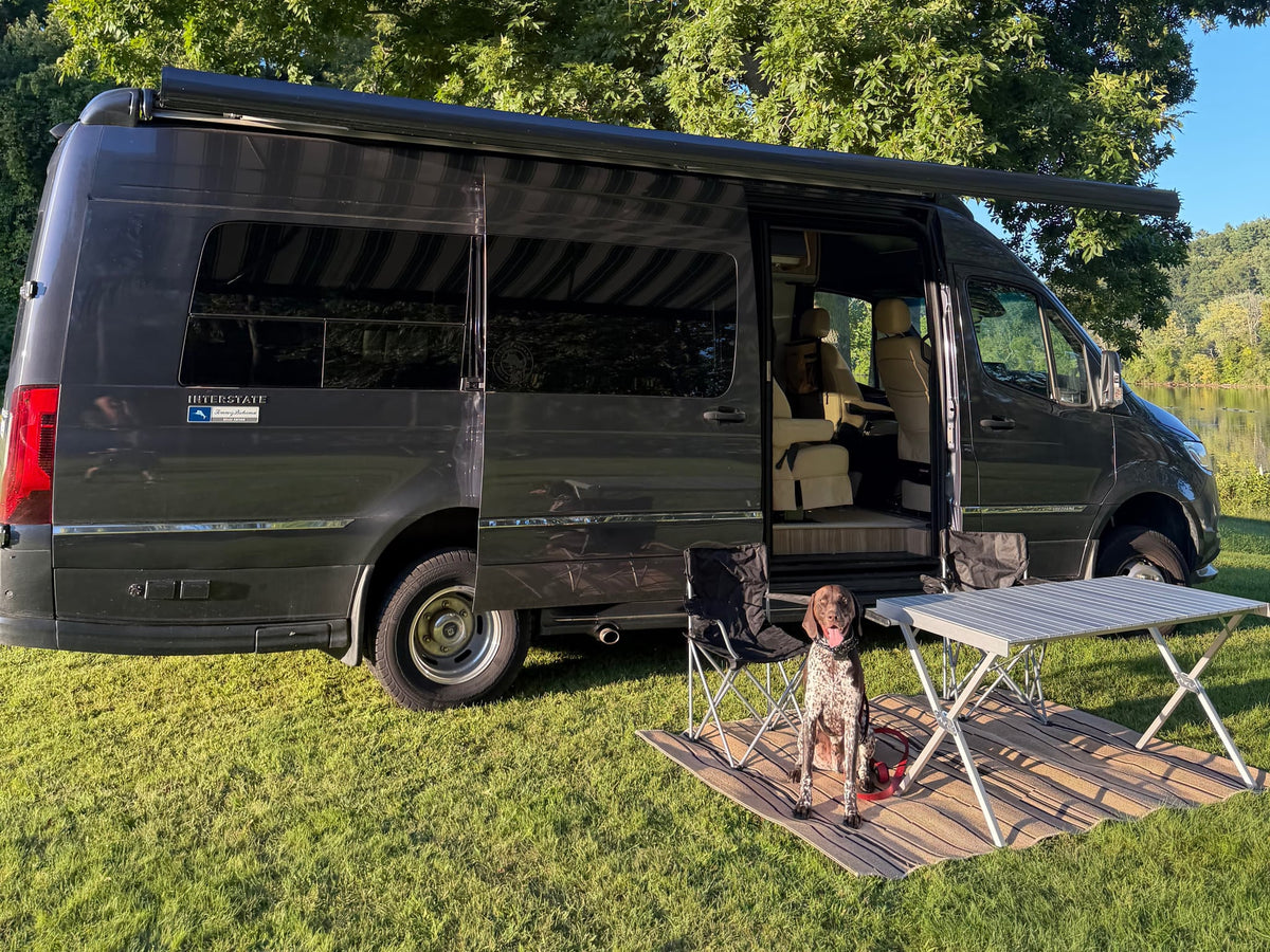  and light-colored seating in a compact camper van.|Cozy RV rental interior with beach views. Enjoy the comfortable seating — photo 12