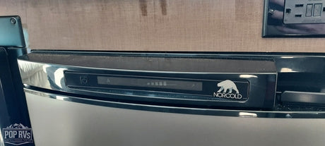 Close-up of a Norcold RV refrigerator's control panel, showing a digital display with power, 'A' mode, and temperature bars. Ideal for rv rental.