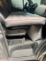 RV rental: van's front cabin converted to a bed with a Luno mattress over the seats, ideal for camper road trips.