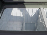 Inside an empty RV rental portable fridge/freezer with dual compartments and wire baskets, ready for your camping or road trip.