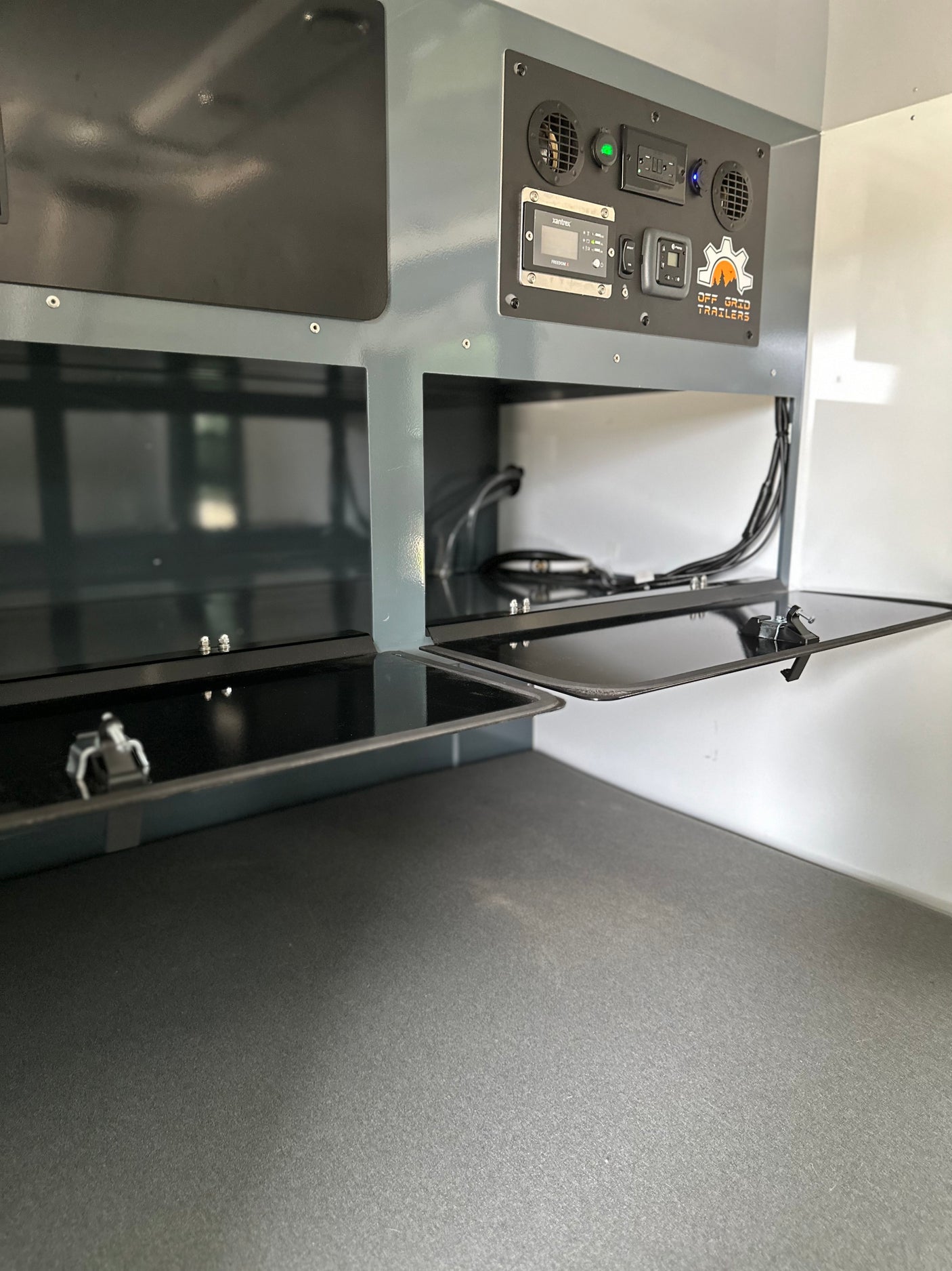 RV rental interior: Off Grid Trailers' gray panel, Xantrex power display, outlets, vents, and handy storage compartments.