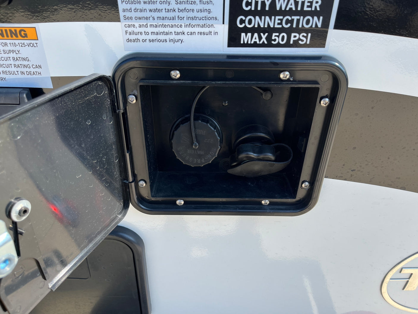 RV rental water utility panel with open access. Details for potable water fill, city water connection (Max 50 PSI), and safety warnings.