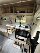 Explore this RV rental's modern interior with a compact kitchen, extensive storage, & comfortable living space.