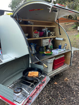 RV rental's outdoor kitchen cooking grilled cheese in a teardrop trailer galley.