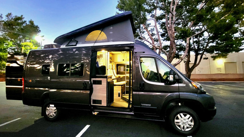 Ready for adventure! This dark grey camper van, pop-top open & interior lit, highlights an ideal rv rental for travel. — photo 12