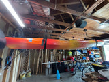 Kayak overhead in garage, alongside bikes and gear, ready for outdoor trips. Consider an RV rental for adventures!