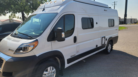 Side view of a white Winnebago camper van, ideal for an RV rental or a fun road trip.
