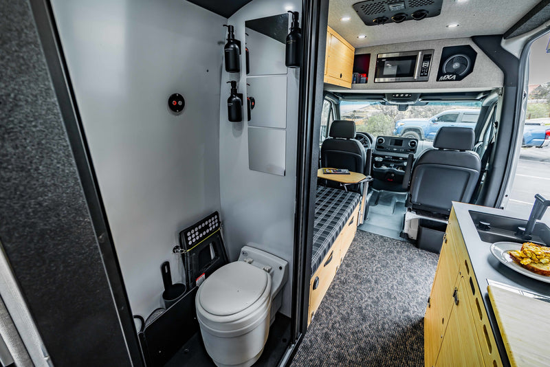  parked on a gravel lot amidst arid hills. Ideal for your next RV rental outdoor adventure.|Inside an RV rental: a modern camper van kitchen with sink — photo 4