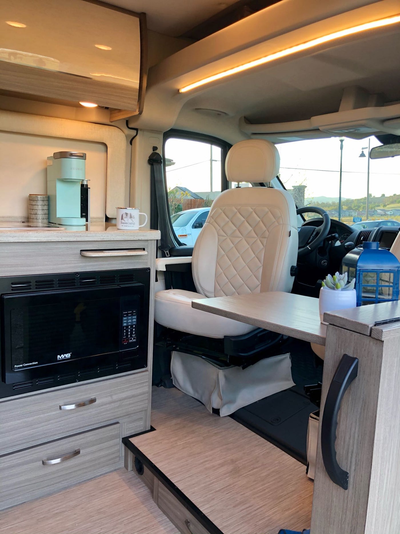 and string lights from the open door.|Spacious RV rental interior with a bright kitchen area — photo 8