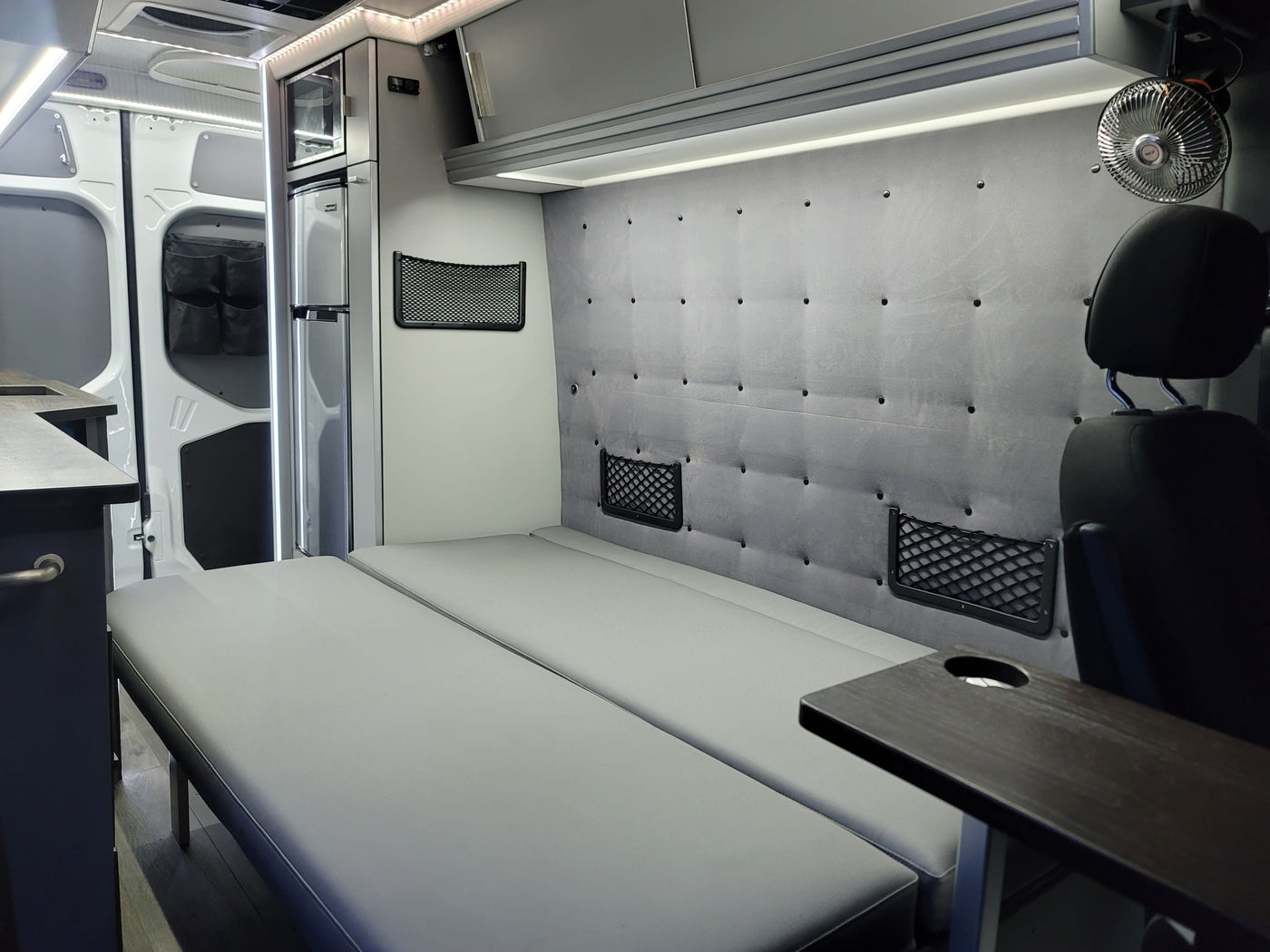  parked by a grassy roadside.|Modern RV rental camper van interior. Convertible bed — photo 7