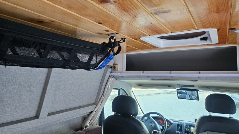 Interior of an RV rental: wooden ceiling, front cab with multi-view rearview screen, and mesh overhead storage. — photo 12