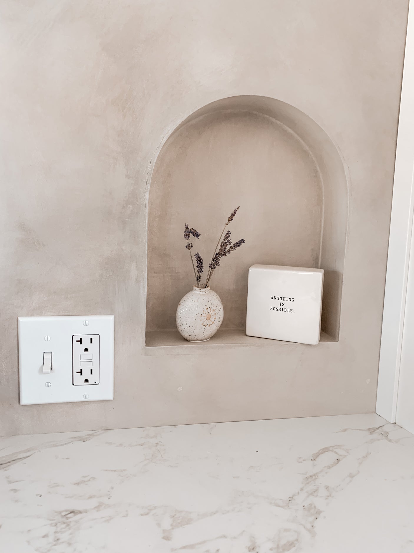 Cozy RV rental interior design: a built-in wall niche with dried lavender, positive decor, and a white countertop.