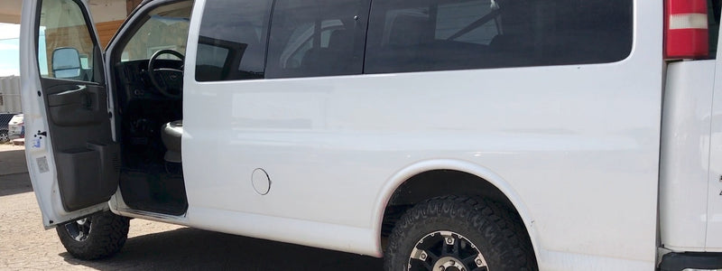 White van RV rental, side view, door open. Features off-road tires, hinting at adventure readiness. — photo 2