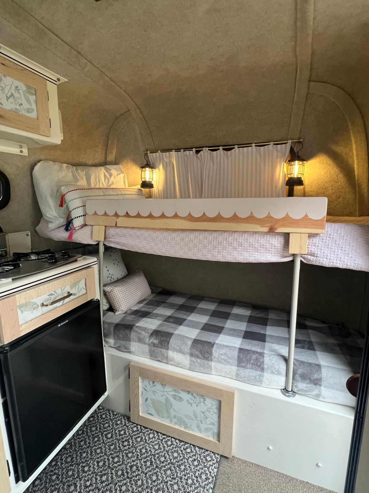 Cozy RV rental interior with bunk beds, compact kitchen, and warm decor, providing comfortable accommodation for travel. — photo 12