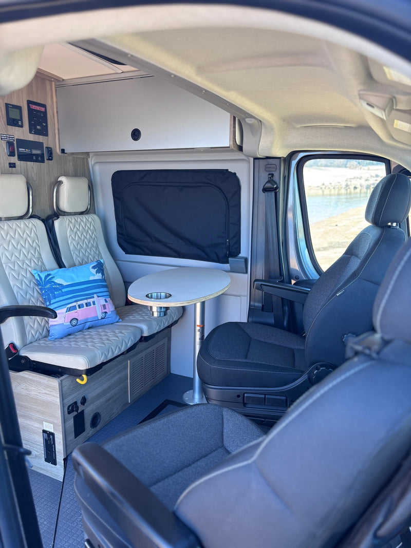 Step inside this cozy rv rental camper van! Features comfortable seating, dining table, and control panel with scenic views outside. — photo 13
