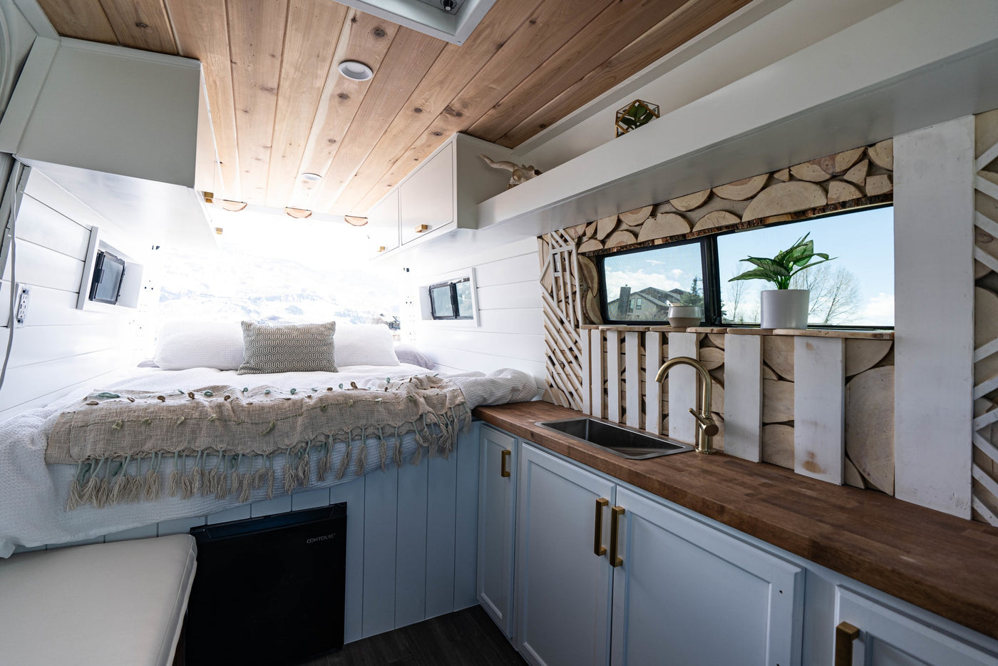  revealing its custom interior conversion.|Inside a modern RV rental: comfy bed — photo 3
