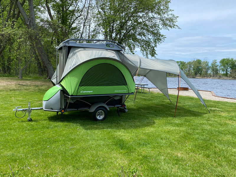 A SylvanSport Go compact camper trailer, perfect for an rv rental, is set up by the lake for outdoor adventures. — photo 8