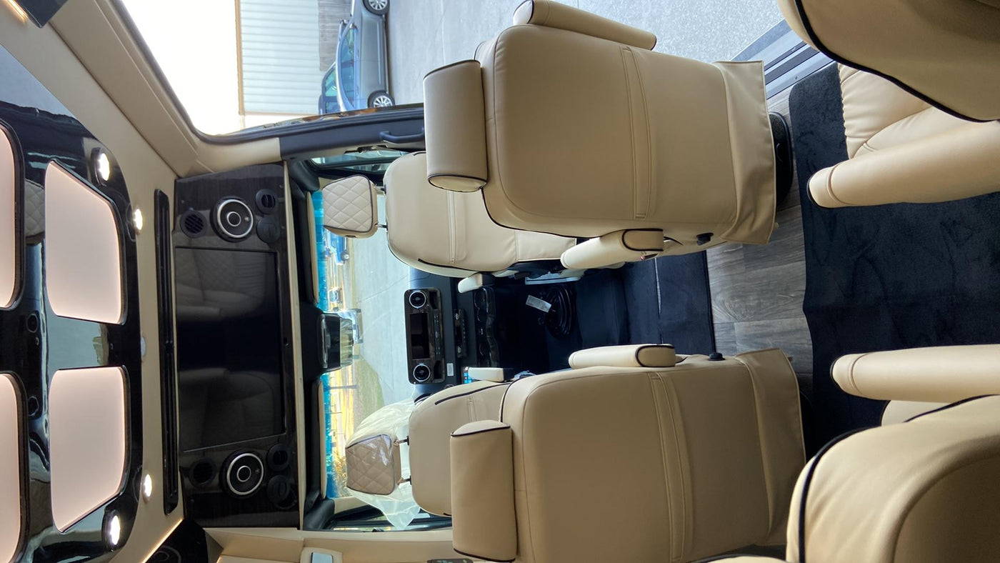  parked on a concrete lot.|Sleek black Mercedes Sprinter 'Ultimate Coach' luxury RV rental van with tinted windows.|Luxury RV rental interior with plush cream leather seats — photo 7