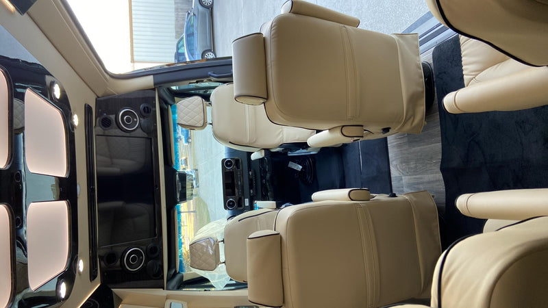  parked on a concrete lot.|Sleek black Mercedes Sprinter 'Ultimate Coach' luxury RV rental van with tinted windows.|Luxury RV rental interior with plush cream leather seats — photo 7